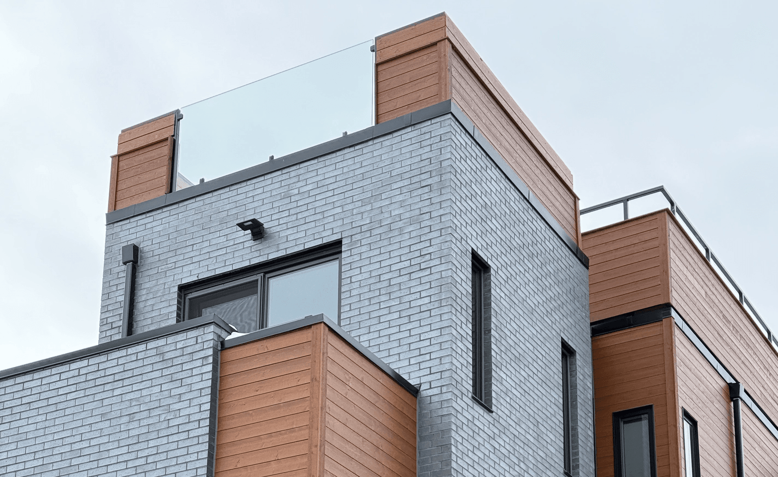 Detail of brick and wood-clad modern home exterior