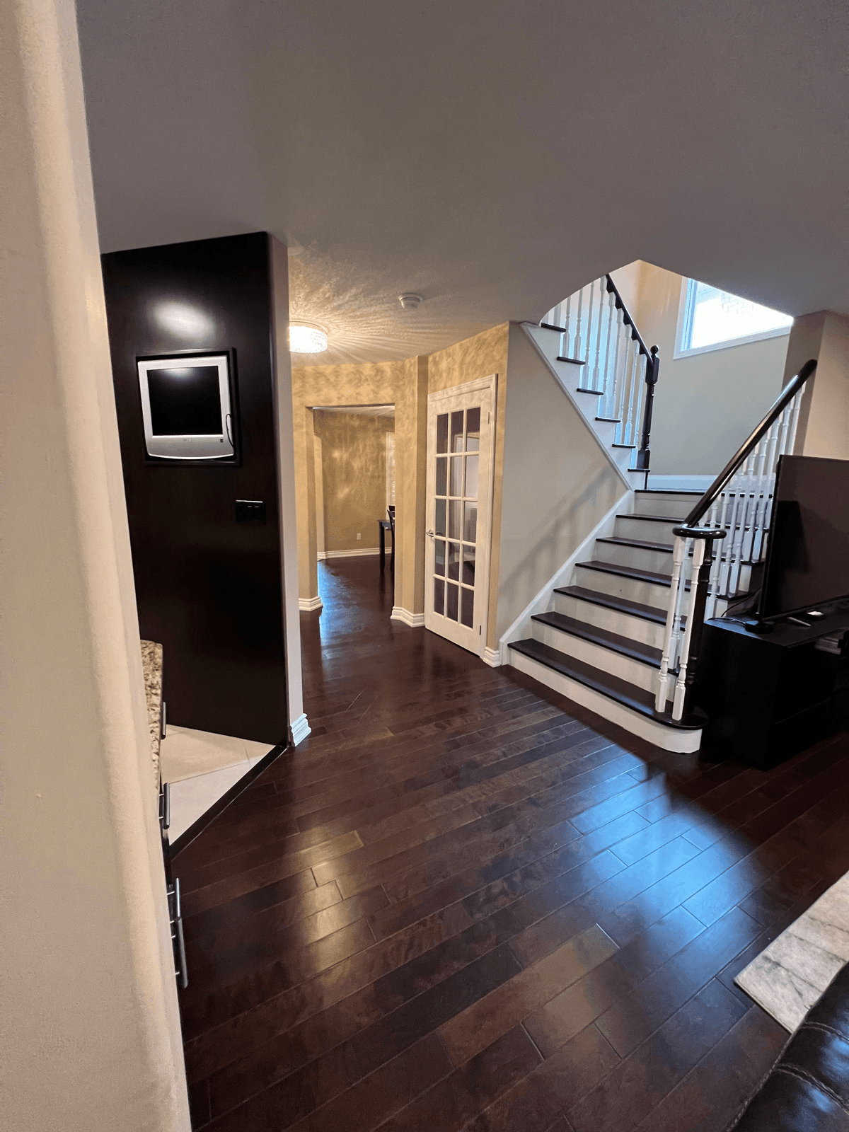 Open main floor with dark hardwood and a staircase